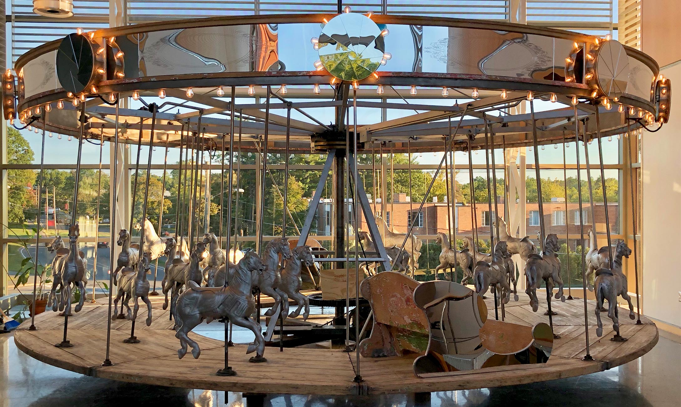 Refurbished carousel in front of large windows.