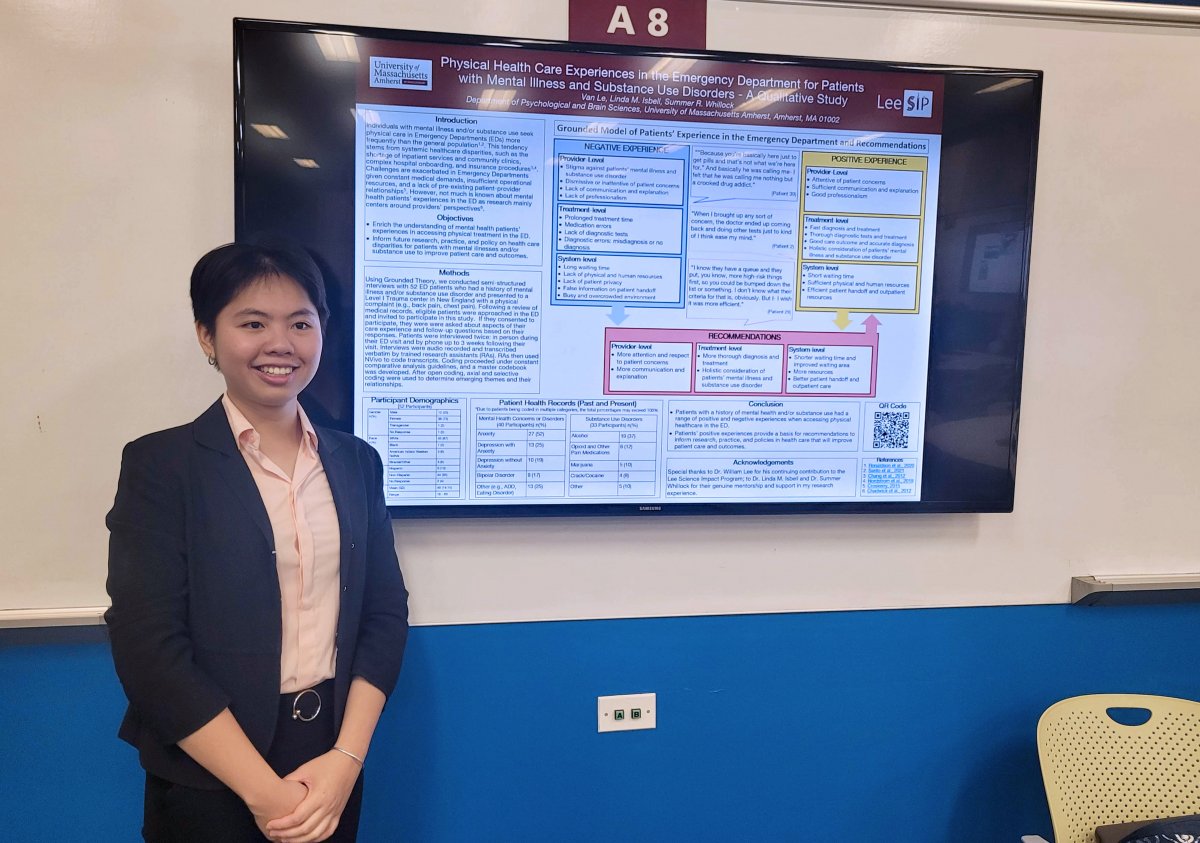 Van Le stands next to research poster